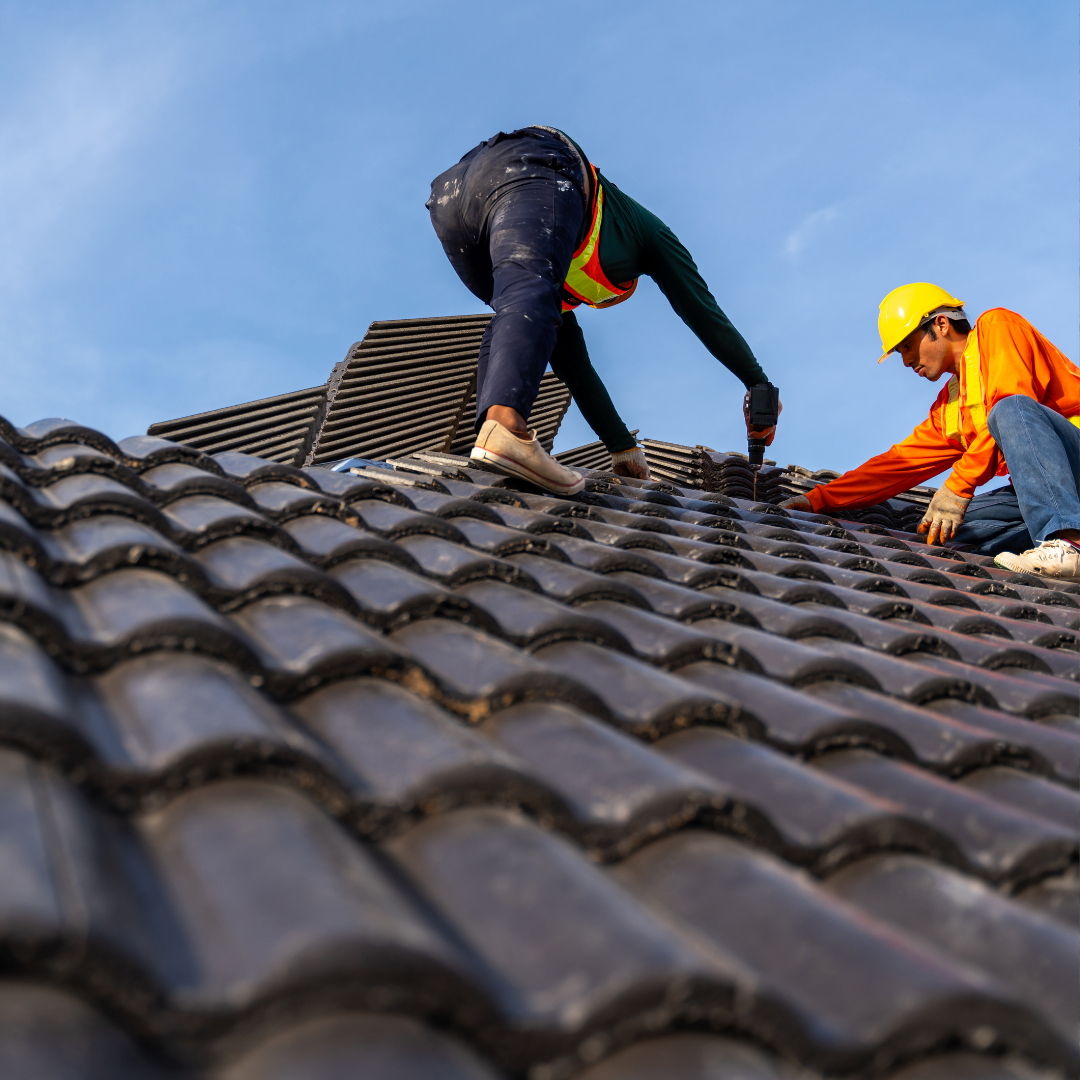 Two roofers fixing the roof.